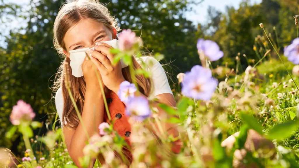 Ceci est l’image d'une enfant en train de se moucher à cause des pollens présents dans l'air. Bannière principale du premier article sur les Plantes dangereuses pour l'homme et les animaux- Article de Blog Rédigé par EcoVerde Parcs et Jardins à Saint-Arnoult-en-Yvelines-en-Yvelines.